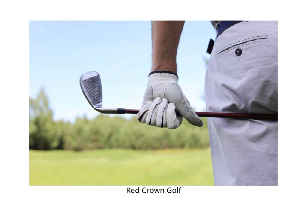 Golfer's gloved hand gripping an iron against the trousers, showing a controlled 90% effort setup