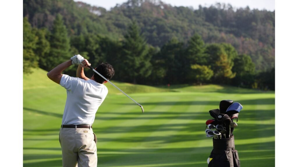 Golfer Follow-Through Reading Ball Flight After the Swing Golfer completing a full swing follow-through with golf bag beside a fairway