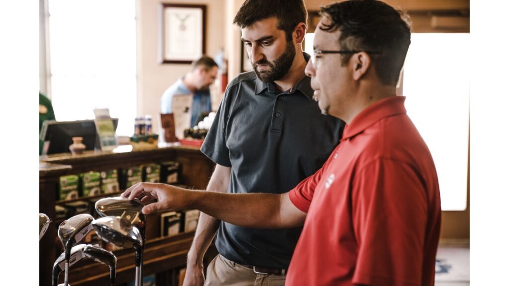 Golf fitter helping a golfer choose the right club during a golf club fitting session