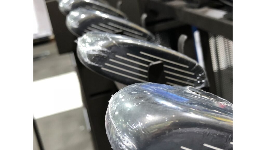 Close-up of golf club heads being compared during a club fitting